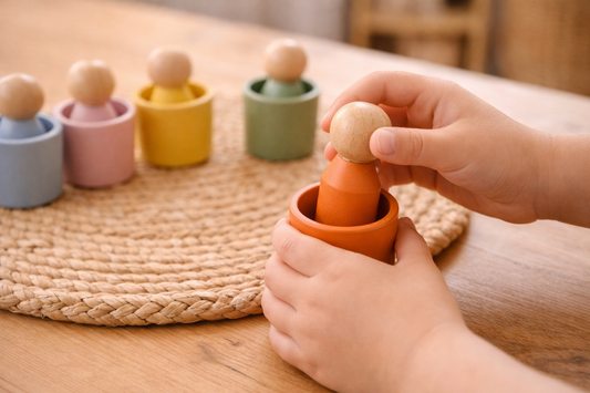 Kind steckt Holzfigur in passenden Becher – Montessori Farblernspiel zur Förderung von Motorik und Konzentration